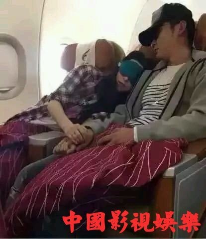 两人在飞机上两人熟睡相互依偎，双手紧握，甜蜜羡煞旁人。